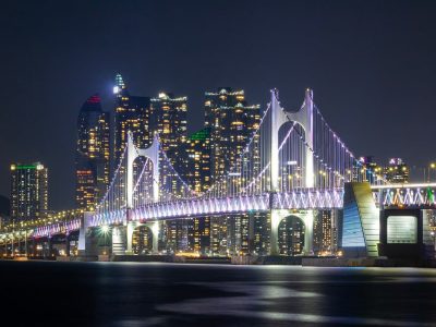 深夜办公室窗外城市灯火，桌上一盏暖光台灯照着翻开的资料册